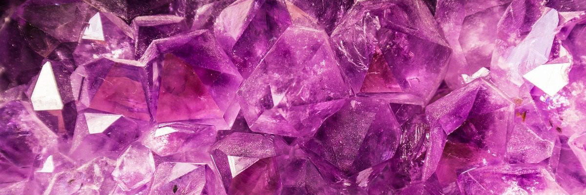 Close-up of faceted amethyst gemstones showcasing rich purple colour and reflective faces. February birthstone detailFebruary Birthstone Amathyst