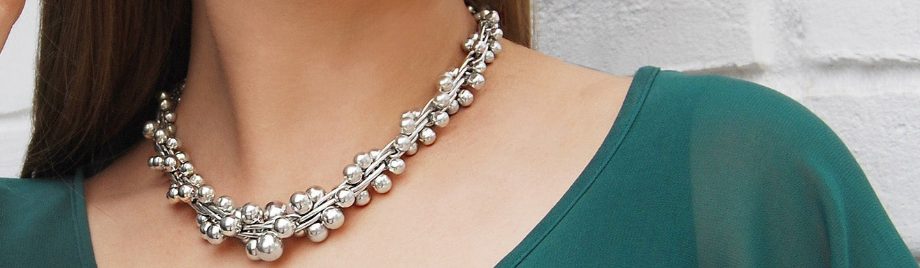 Silver chunky Peppercorn necklace bbeing worn by a girl with a green scooped top.