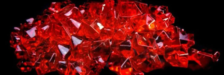 Close-up of uncut red ruby gemstones on a black background - July birthstone detail