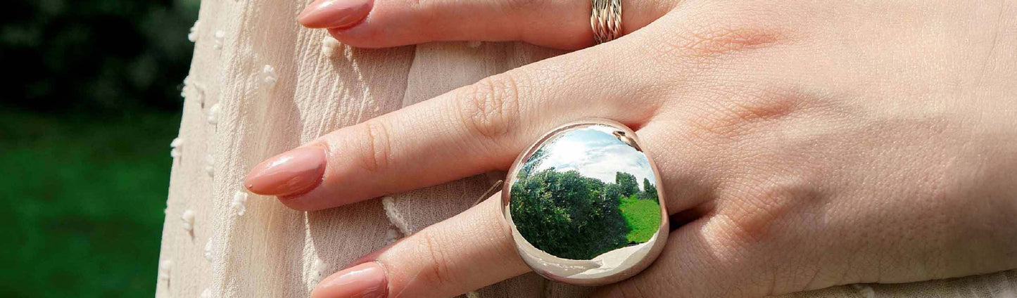 Image of a womand hand wearing a statement sphere ring