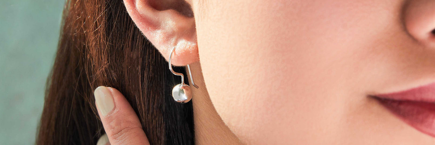 Close up of a woman wearing a Sterling Silver Dangle ball earring