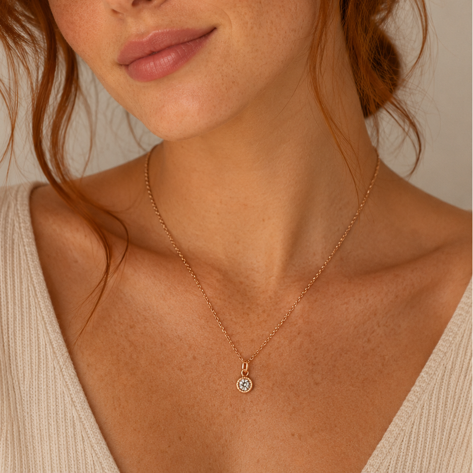 Woman wearing a delicate rose gold gemstone necklace against a neutral background